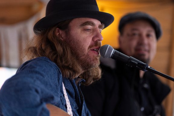 Mama's Greens on stage, singing and playing.