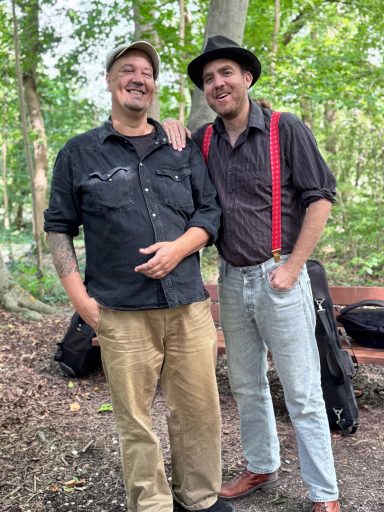 Mama's Greens standing between forest trees, smiling.