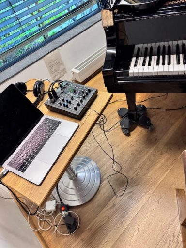 Laptop, audio interface and grand piano during the recording session for "Lament."
